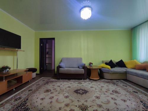 sala de estar con sofá y silla en Апартаменты 2-х комнатные в Степногорске en Stepnogorsk