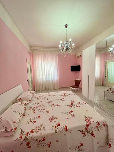 - une chambre avec un grand lit fleuri dans l'établissement La Maison De Rose, à Torre Annunziata