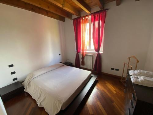Schlafzimmer mit einem Bett und einem Fenster mit roten Vorhängen in der Unterkunft Garda Lake Dana Home in Salò