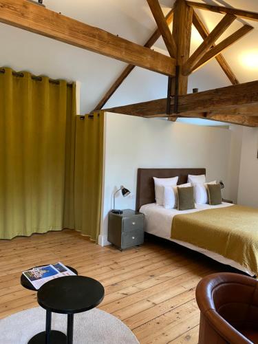 a bedroom with a bed and a table in a room at Le Clos des Queyries in Bordeaux