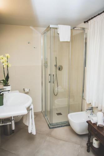 a bathroom with a glass shower and a sink at Agriturismo Rivella in Barbaresco