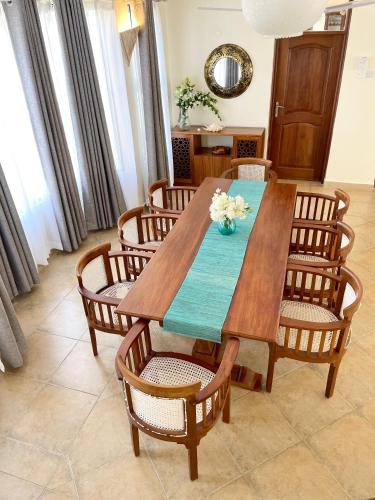a dining room with a wooden table and chairs at Villa Macheo in Mombasa