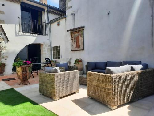 a patio with wicker chairs and a couch at Mas" La Maison de mon Père " Proche AVIGNON à PUJAUT in Pujaut