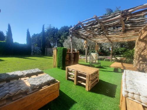 a garden with a wooden pergola and a table at Mas" La Maison de mon Père " Proche AVIGNON à PUJAUT in Pujaut