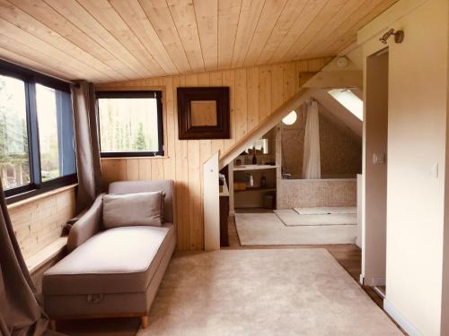 uma pequena sala de estar com um sofá e uma escada em Clairseine em Tournedos-sur-Seine