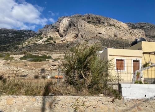 a building in the desert with a mountain in the background at Grannys Villas finiki in Karpathos Town