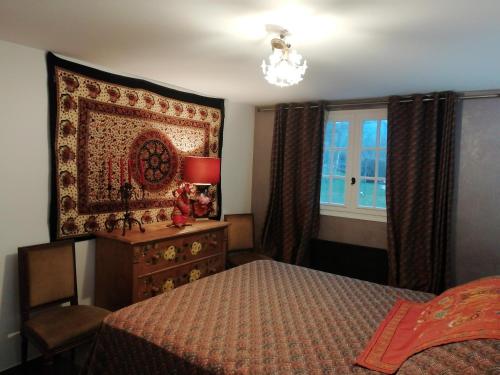 une chambre avec un lit, une commode et une fenêtre dans l'établissement Aux 3 Licornes, à Nevy-sur-Seille