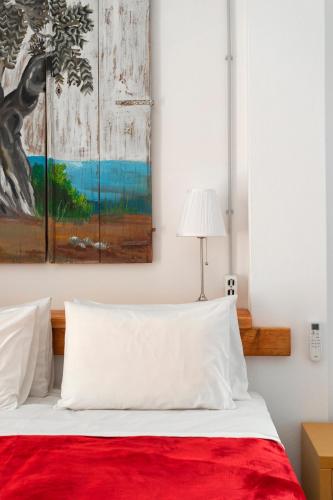 a bedroom with a bed with a red blanket at Condillia Central in Spetses