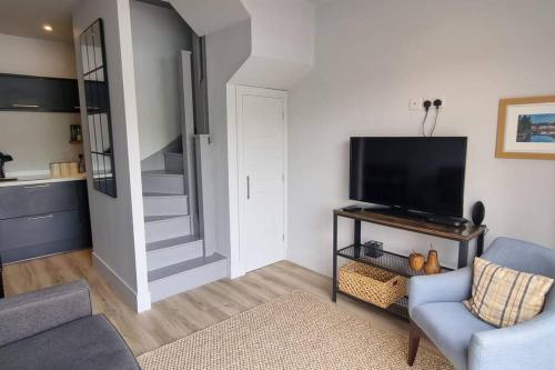 a living room with a tv and a blue chair at The Nest in Coveney