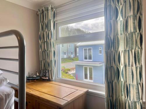 a bedroom with a window with a desk and a bed at Pass the Keys Seaside Escape Freshwater East in Pembroke