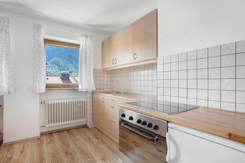 a kitchen with a stove top oven next to a window at Wohnung Hochstaufen in Inzell