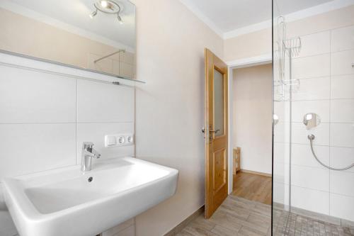 La salle de bains est pourvue d'un lavabo et d'une douche. dans l'établissement Wohnung Hochstaufen, à Inzell