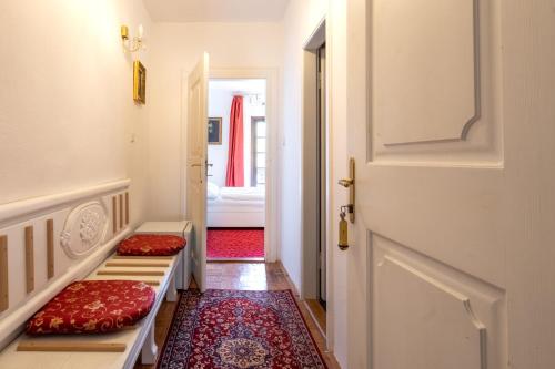 a hallway with a door and two red pillows at Leylaria in Český Krumlov