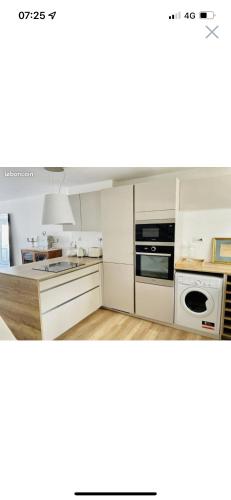 une cuisine avec des armoires blanches et un four à plaques de cuisson dans l'établissement Marina Port Camargue appontement bateau, au Grau-du-Roi