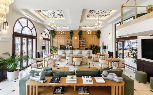 een lobby van een restaurant met tafels en stoelen bij Diverso Platamon, Luxury Hotel & Spa in Platamonas