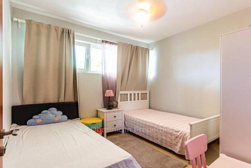 een kleine slaapkamer met 2 bedden en een raam bij Infinity blue family suite in Sosúa
