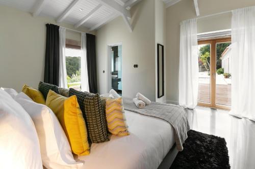 a living room with a white couch with yellow pillows at Casa do Vale in Óbidos