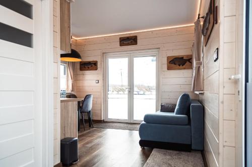 a living room with a blue couch and a kitchen at Kraina Poraj in Kolonia Pętkowice