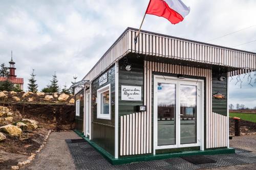 a small building with a flag on top of it at Kraina Poraj in Kolonia Pętkowice