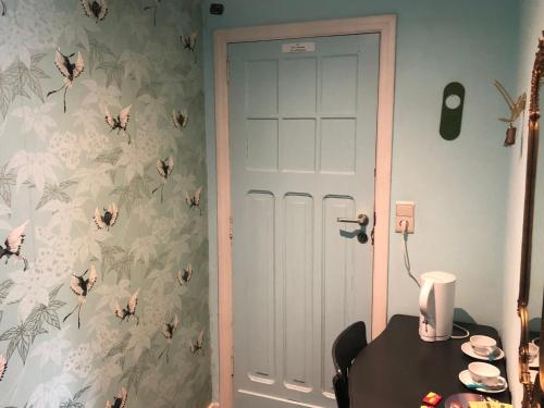 a room with a table and a door with butterfly wallpaper at Les Lumerettes - Dohan in Bouillon