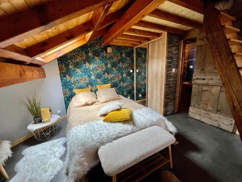 a bedroom with a bed in a room with wooden ceilings at Le Mélèze in Villar-Saint-Pancrace