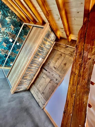 une pièce avec du parquet et un mur avec des plantes dans l'établissement Le Mélèze, à Villar-Saint-Pancrace