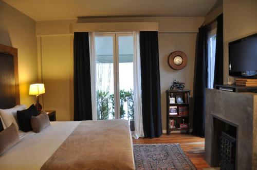 a bedroom with a bed with a fireplace and a tv at Legado Mitico Buenos Aires in Buenos Aires