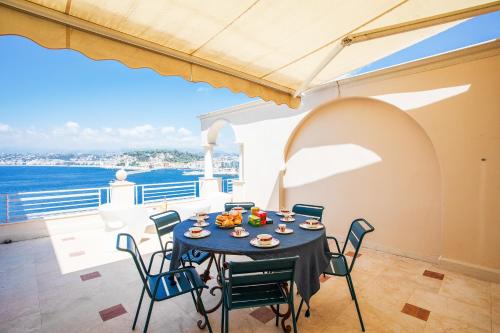 une salle à manger avec une table et des chaises et l'océan dans l'établissement LE CAP DE NICE VI4150 by RIVIERA HOLIDAY HOMES, à Nice
