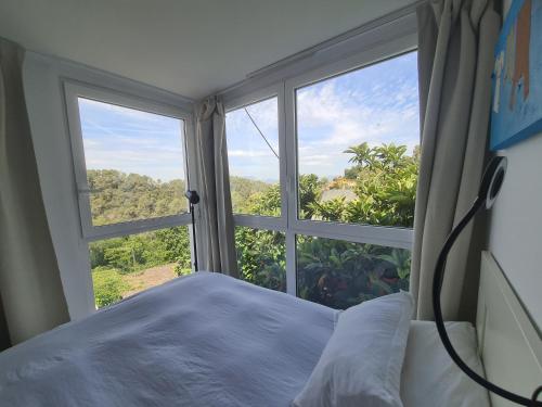 ein Schlafzimmer mit einem Bett und einem großen Fenster in der Unterkunft Nature Oasis near Barcelona with swimming pool in Sant Cugat del Vallès