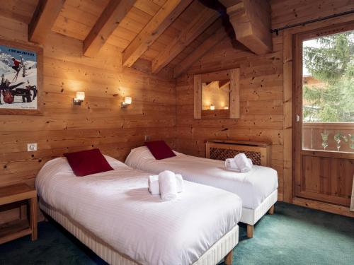 a bedroom with two beds in a log cabin at Chalet Méribel, 5 pièces, 8 personnes - FR-1-688-18 in Méribel