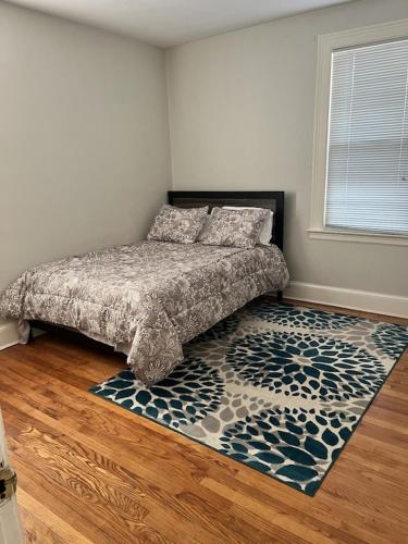 1 dormitorio con cama y alfombra en el suelo en Secret Oasis In The Heart Of Hartford, en Hartford