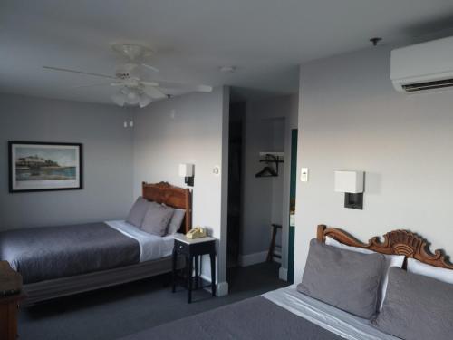 a bedroom with two beds and a ceiling fan at National Hotel in New Shoreham