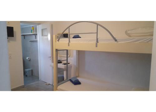 PaliochoriにあるSummer House Paliochoriの二段ベッド1組、バスルームが備わる小さな客室です。