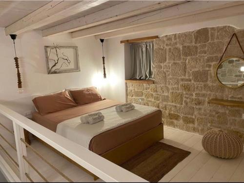 a bedroom with a bed in a brick wall at Grannys Luxury Villas in Karpathos
