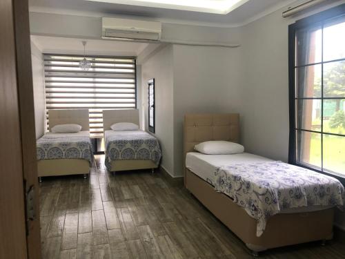 a bedroom with two beds and a window at Seyran Seaside Apartments- 2-garden floor in Trabzon