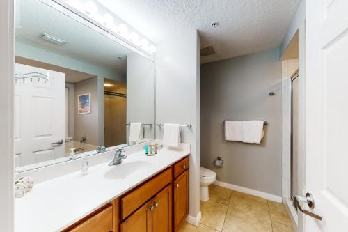 a bathroom with a sink and a toilet and a mirror at Destin West Gulfside Villa V402 in Fort Walton Beach