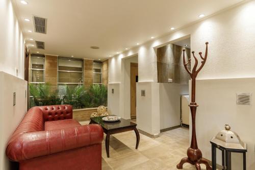 a living room with a red couch and a table at Diverso Platamon, Luxury Hotel & Suites in Platamonas