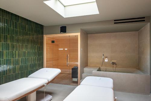 un bagno con 2 letti e una vasca da bagno di Limen Wellness Hotel & Spa a Campofelice di Roccella