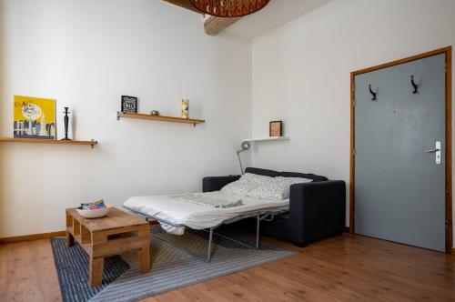 a room with a bed and a table and a door at Le Central in Avignon