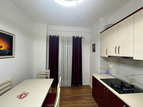 a kitchen with white cabinets and a table with a counter top at Cosy 2BR Apartment near Tirana Airport - SELF CHECK-IN 24hr in Tirana