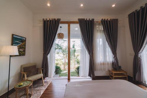 a bedroom with a bed and a large window at 3 Tầng Mây (Homestay & Coffee) in Ấp Ða Lôc