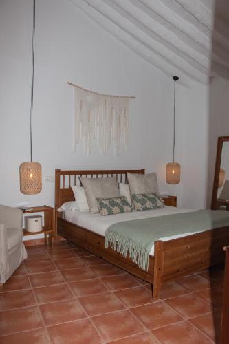 a bedroom with a large bed and two lamps at Acogedora Casa Rural en Olvera La Morada in Olvera