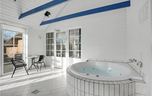 Bøtø ByにあるStunning Home In Vggerlse With Sauna, Wifi And Private Swimming Poolの白い広いバスルーム(バスタブ、テーブル付)