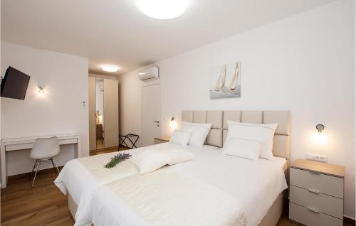 1 dormitorio blanco con 1 cama blanca grande con almohadas blancas en Nice Home In Turanj With House Sea View, en Turanj