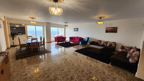een woonkamer met een bank, stoelen en een tafel bij Midpoint Sea View - families only in Alexandrië