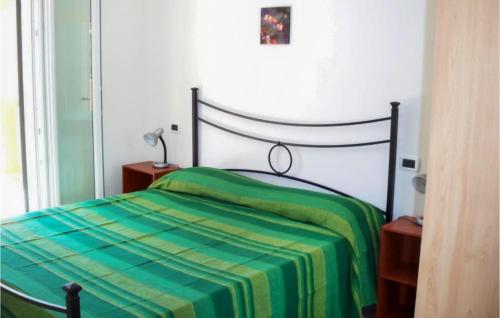 um quarto com uma cama com um cobertor verde e amarelo em 2 Bedroom Beautiful Apartment In Valledoria em Valledoria