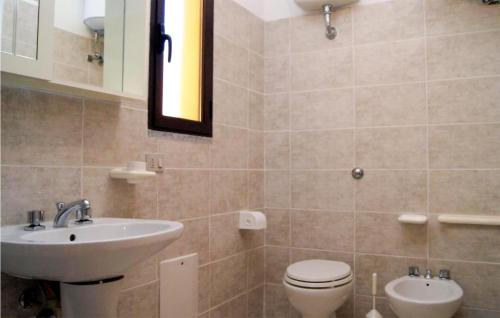 uma casa de banho com um lavatório, um WC e um espelho. em 2 Bedroom Beautiful Apartment In Valledoria em Valledoria