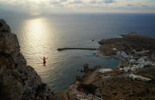 Eine Person, die von einer Klippe ins Wasser springt. in der Unterkunft Grannys Luxury Villas in Karpathos