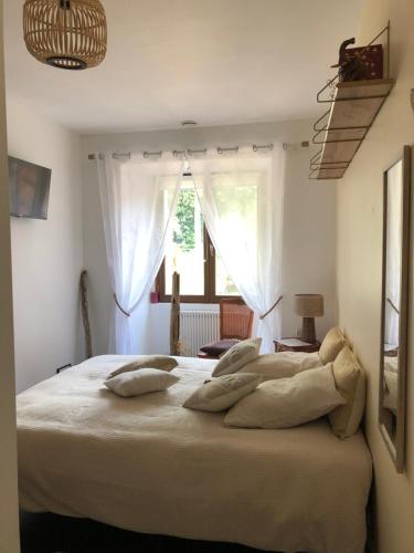 a bedroom with a large bed with pillows on it at Bras de Mer in Cérans-Foulletourte