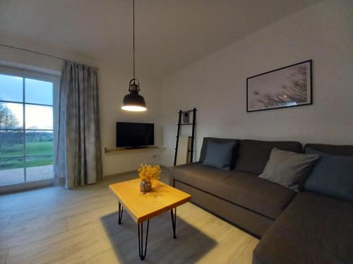 a living room with a couch and a table at Ferienwohnung Landblick in Steenfeld